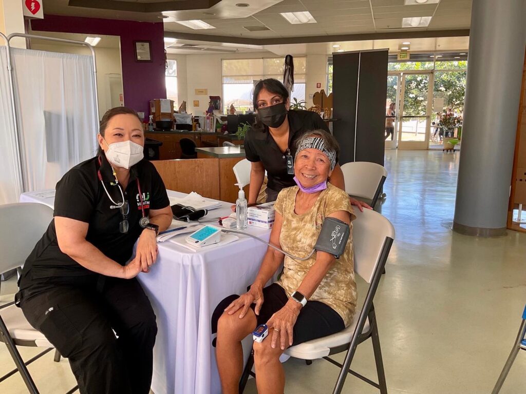 Senior woman getting her blood pressure checked at a health station.