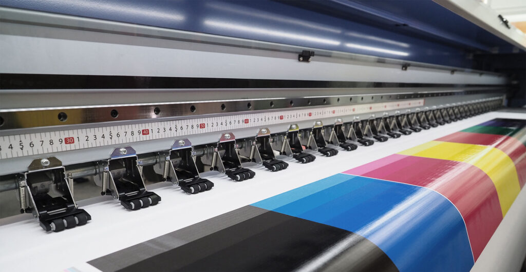 Wide-format printer printing CMYK bands.
